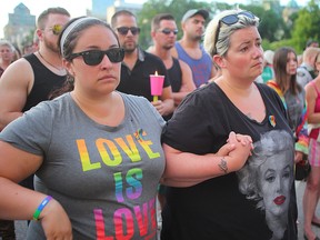 Two women hold hands during a vigil for the Orlando shooting victims in Winnipeg, Man. Monday June 13, 2016.
Brian Donogh/Winnipeg Sun/Postmedia Network