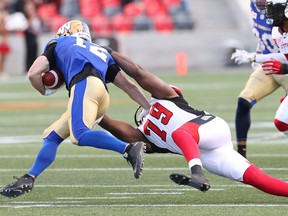 Martin Wright (R) of the Ottawa RedBlacks tackles #12 Ryan Smith of the Winnipeg Blue Bombers during first half action at TD Place in Ottawa, June 13, 2016.