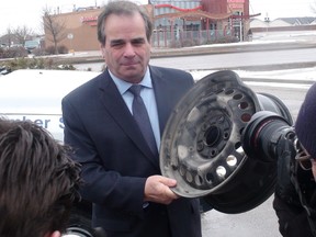CAA Manitoba president and CEO Mike Mager holds a bent rim caused by hitting a pothole at a Winnipeg press conference last year. (JIM BENDER/WINNIPEG SUN FILE PHOTO)