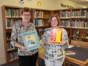 Sarnia Public Library's Theresa Lecky and Krystyna Stalmach hold some long, long overdue books returned during the library's two-week amnesty in May.
CARL HNATYSHYN/SARNIA THIS WEEK