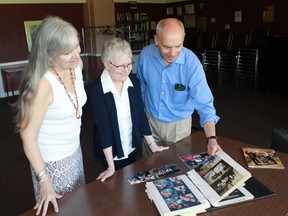 Unitarians Wendy Starr, Ann Steadman and Allan McKeown flip through a book of photographs documenting 60 years of Unitarianism in Sarnia and Port Huron. 
CARL HNATYSHYN/SARNIA THIS WEEK