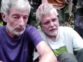 This file image made from undated militant video, shows Canadians Robert Hall, left, and John Ridsdel, right. With a black Islamic State group-style flag as a backdrop, Abu Sayyaf fighters beheaded Canadian hostage Hall on southern Jolo island on Monday, June 13, 2016,  after a ransom deadline passed.  Enraged by the beheading of a second Canadian hostage by ransom-seeking Abu Sayyaf extremists, Philippine troops pressed a major offensive in the south Tuesday, June 14, 2016,  but there was no sign of an end to the small but brutal insurgency that a new president will inherit in about two weeks. (Militant Video via AP Video, File)