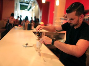 This is a Sunday, Aug. 2, 2015 file photo of Walter Martin as he prepares a coffee in his coffee shop in the colonial district of Old San Juan, Puerto Rico.  The World Health Organization's research arm has downgraded its classification of coffee as a possible carcinogen, declaring there isn't enough proof to show a link to cancer. But the International Agency for Research on Cancer, or IARC, also announced in a report published on Wednesday June 15, 2016 that drinking "very hot" beverages of any kind could potentially raise the cancer risk. (AP Photo/Ricardo Arduengo, File)