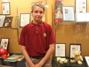Brandon Raes in front of his exhibit’s object which are wooden shoes. His grandfather brought the shoes from Belgium when he immigrated in 1922. (Justine Alkema/Clinton News Record)