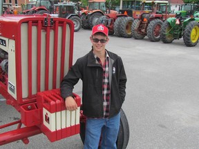 Daniel Leaper, 17, stands next to his family's restored Farmall 806 tractor on Tractor Day, in the parking lot at Lambton Central Collegiate Vocational School (LCCVI) on Wednesday June 15, 2016 in Petrolia, Ont. (Paul Morden/Sarnia Observer)