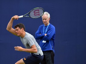 Canada’s Milos Raonic is watched by John McEnroe during a practice session at the ATP tournament at Queen’s Club, in London June 13, 2016. (AFP PHOTO/GLYN KIRK)