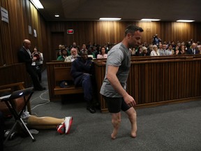 Oscar Pistorius' prosthetics lay on the floor as he walks on his stumps during argument in mitigation of sentence by his defense attorney Barry Roux in the High Court in Pretoria, South Africa, Wednesday, June 15, 2016. An appeals court found Pistorius guilty of murder and not a lesser charge of culpable homicide for the shooting death of his girlfriend Reeva Steenkamp. (Siphiwe Sibeko, Pool Photo via AP)