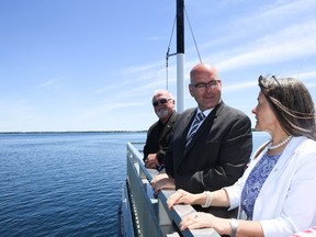 Ontario Transportation Minister Steven Del Duca, centre, Loyalist Township Mayor Bill Lowry and Kingston and the Islands MPP Sophie Kiwala ride on the Frontenac II prior to announcing the schedule for the arrival of a new ferry in Millhaven, Ont. (Elliot Ferguson/The Whig-Standard)