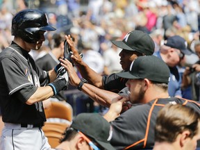 Miami Marlins’ Ichiro Suzuki, left, is greeted at the dugout after their 6-3 loss against the San Diego Padres in a baseball game, Wednesday, June 15, 2016, in San Diego. (AP Photo/Gregory Bull)