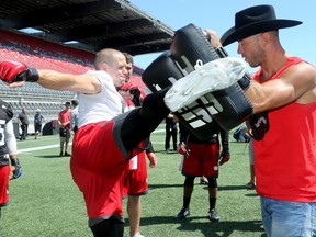Redblacks’ Jake Harty (left) gets a lesson from UFC fighter Donald Cerrone on how to kick at TD Place. (Julie Oliver, Postmedia Network)