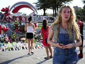 Shelby Sloan, 29, of Orlando cries as she walks away from a memorial at Orlando Health on June 15, 2016, in Orlando, Fla. The city and nation is still feeling the effects of the June 12 mass shooting in an Orlando nightclub – Pulse. "I hope they can be healed and find peace," Sloan said of the victims families. (Corey Perrine/Naples Daily News via AP)