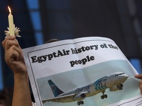 In this May 24, 2016 file photo, an Egyptian journalist holds a candle and a poster supporting EgyptAir during a candlelight vigil for the victims of EgyptAir flight 804 in front of the Journalists' Syndicate in Cairo, Egypt. (AP Photo/Amr Nabil, File)