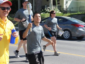 Samantha reed/The Intelligencer
Local athlete Donald Winter carries the torch down North Front Street during the annual Law Enforcement Torch Run for Special Olympics Thursday morning.