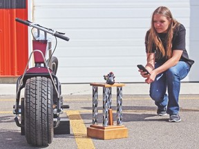 Erica Penner of the Carmangay Outreach team takes a photo of the school team's chopper and the trophy the team won in the Biker Build-Off Challenge. Photo courtesy of Palliser Regional Schools