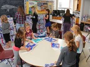 Students at St. Patrick Catholic School enjoy spending their recess working on the Milk Bag Mat Project by cutting, tying and weaving more than 10,000 milk bags into child sized mats together to send overseas in Harrowsmith, Ont. on Monday June 13, 2016. The 230 students and organizers are looking to make 100 mats before the end of the school year. Julia McKay/The Whig-Standard/Postmedia Network