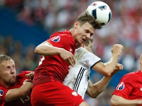 Poland’s Lukasz Piszczek, middle, heads the ball away from teammate Kamil Glik, left, and Germany’s Thomas Mueller during the Euro 2016 match at the Stade de France in Saint-Denis, north of Paris, Thursday, June 16, 2016. (AP Photo/Christophe Ena)