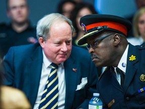 Toronto Police Service Chief Mark Saunders (right) and Toronto Police Services Board chair Andy Pringle wait to address media on the interim report of the future of policing at police headquarters in Toronto Thursday, June 16, 2016. (Ernest Doroszuk/Toronto Sun)