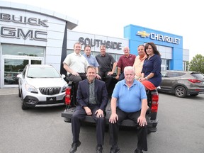 Denis Lauzon, general manager, and Bruce Wells, sales manager, sit on the tailgate, along with sales team Jonathan Duquette, Robin Lamothe, Brad Lefebvre, Tim Gordon, Len Crocco and controller Nicole Courville at Southside Chevrolet Buick GMC in Sudbury, Ont. Gino Donato/Sudbury Star/Postmedia Network