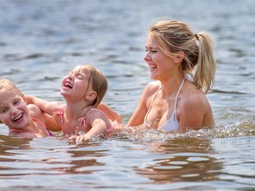 Sydney LaBossiere, with Alyssa Levesque, (L) and her sister Anna Levesque, enjoy a cool dip in Mooney's Bay. Wayne Cuddington/Postmedia