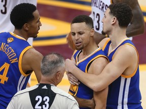 Golden State Warriors guard Stephen Curry is held back from referee Jason Phillips by Shaun Livingston, left, and Klay Thompson, right, after being called for his sixth foul during Game 6 of the NBA Finals in Cleveland, Thursday, June 16, 2016. (AP Photo/Ron Schwane)