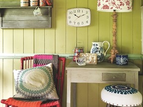 A painted timber wall, red vintage style wicker chair and blue-topped chair help to create a relaxed vibe.
