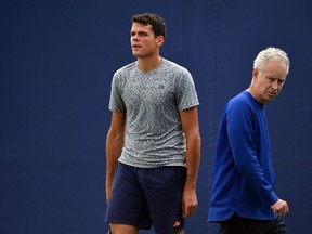 Canada’s Milos Raonic is watched by John McEnroe during a practice session at the ATP tournament at Queen’s Club in London June 13, 2016. (AFP PHOTO/GLYN KIRK)