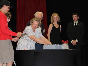 Class of 2016 Queen Elizabeth Collegiate and Vocational Institute students  (from right) Ryan Buell-Lowes, Missy McFadden and Tanner Abrams (far left) along with members of the class of 1955, (from left) Eileen Maille, Phyllis Turrel and Robbie Preston, place items into a time capsule during the schools farewell ceremony in Kingston, Ont. on Friday, June 17, 2016. The capsule will be placed under the new school to be built on the site.  Jane Willsie for The Whig-Standard/Postmedia Network