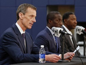 Minnesota Timberwolves assistant coach Sam Mitchell, right, listens as CEO Rob Moor, left, names Mitchell interim head coach, while head coach Flip Saunders takes a leave of absence, during a news conference Friday, Sept. 11, 2015 in Minneapolis.  (AP Photo/Jim Mone)