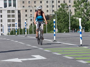 City crews are having to replace flexible posts used on Laurier Avenue East to keep cars out of the bike lane almost daily because they are being removed. Wayne Cuddington/Postmedia