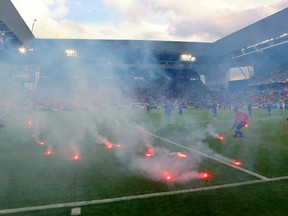 Flares are thrown onto the pitch during the Euro 2016 Group D match between the Czech Republic and Croatia at the Geoffroy Guichard stadium in Saint-Etienne, France, on Friday, June 17, 2016. (Darko Bandic/AP Photo)