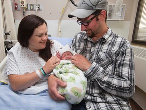 Melissa Taylor and Steven Mercer hold their son Eli Danny Roy Mercer, the first baby to be born in Fort McMurray since the wildfire evacuation, in Fort McMurray Alta. on Friday June 17, 2016.