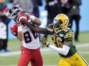 Calgary Stampeders' Anthony Parker (L) has the ball knocked out of his hands by Edmonton Eskimos' John Ojo during their CFL Western Final football game in Edmonton November 22, 2015.