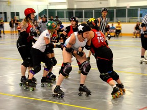 Janet Young/for The Sudbury Star
Hipcheck Liddell (Krista Paul, on the right in red) tries to hold back the opposing jammer from getting through the pack in June 2015.