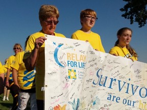 From left, Diane Passingham, Doris Carey, Tyler Linker and Adara Haskins lead the survivors' lap during the Sarnia Relay for Life on Friday. The 15th annual local event ran from 6 p.m. to midnight. Terry Bridge/Sarnia Observer/Postmedia Network