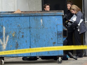 London Police investigators examine a dumpster behind an apartment building on Mill Street in London, Ontario where the body of a baby was found on Thursday June 16, 2016. (MORRIS LAMONT, Free Press file photo)