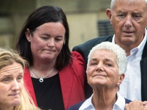 Kim Leadbeater, left, the sister of Labour Member of Parliament, Jo Cox, speaks to the media as she visited floral tributes with her parents Jean, right, and Gordon Leadbeater, rear right, in Birstall, northern England, Saturday June 18, 2016. The man accused of a murder that has brought campaigning in the country's European Union referendum to a standstill turned his first court appearance Saturday into a chilling spectacle by refusing to state his real identity. Jo Cox, 41, died after being shot and stabbed in the street outside her constituency surgery in Birstall, near Leeds, on Thursday.  (Danny Lawson/PA via AP)