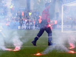 A fire fighter extinguishes flares lobbed onto the pitch during the Euro 2016 match between Czech Republic and Croatia at the Geoffroy-Guichard stadium in Saint-Etienne on June 17, 2016. (AFP PHOTO/Joe KLAMAR)