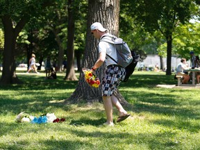 Michael Patterson brings a bouquet of flowers to a spot where a man was killed after being struck by a falling tree branch on Friday evening at Trinity Bellwoods Park on Saturday June 18, 2016. Patterson was one of the first people to respond after he heard a woman's shrieks. Jack Boland/Toronto Sun/Postmedia Network