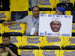 Fans hold a sign of LeBron James before Game 5 of the NBA Finals between the Golden State Warriors and the Cavaliers in Oakland, Calif., Monday, June 13, 2016. (AP Photo/Eric Risberg)