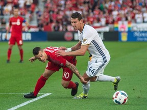 Toronto FC’s Sebastian Giovinco (left) battles LA Galaxy’s Daniel Steres during the first half on Saturday night at BMO Field. The hosts won 1-0. (THE CANADIAN PRESS/PHOTO)