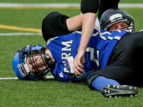 Edmonton Storm's Mickey Did (front) grimaces as she falls after being tackled by Lethbridge Steel's Kendall Bowes (rear) during Western Women's Canadian Football League West Division final playoff game action at Jasper Place Bowl in Edmonton on June 18, 2016.