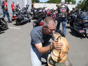 Lawrence Christensen enjoys some face time with his service dog, Lucy, during Juno Riders Barks and Bikes motorcycle ride to raise funds for Cambridge-based National Service Dog.