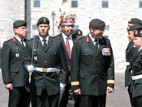 Brig.-Gen. Jocelyn Paul and Dan Grant, chief administrative officer for the Mohawks of the Bay of Quinte, review the graduates of the Aboriginal Leadership Opportunity Year at their graduation parade at the Royal Military College of Canada on Friday. (Steph Crosier/The Whig-Standard)
