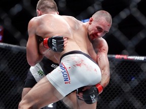 Stephen Thompson (front) and Rory MacDonald grapple during their bout at UFC Fight Night at TD Place on Saturday. (Canadian Press)