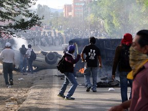 A man uses a slingshot as protesting teachers battle all day with riot police in the state of Oaxaca, near the town of Nochixtlan, Mexico, Sunday, June 19, 2016. The teachers are protesting against plans to overhaul the country's education system which include federally mandated teacher evaluations.(AP Photo/Luis Alberto Cruz Hernandez)