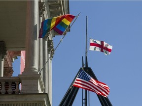 A Gay Pride and a U.S. flag fly from Montreal city hall as a Montreal flag flies at half mast in the background, in Montreal, Monday June 13, 2016, a day after 49 people were shot dead at an Orlando gay club. The shooter was killed after police intervened.  (Phil Carpenter/MONTREAL GAZETTE)