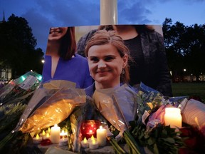 Floral tributes and candles are placed by a picture of slain Labour MP Jo Cox at a vigil in Parliament square in London on June 16, 2016. Cox died after a shock daylight street attack, throwing campaigning for the referendum on Britain's membership of the European Union into disarray just a week before the crucial vote. (DANIEL LEAL-OLIVAS/AFP/Getty Images)