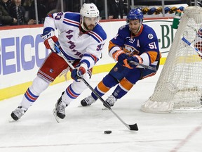 New York Rangers' Keith Yandle (93) and New York Islanders' Frans Nielsen (51) fight for the puck during the second period of an NHL hockey game Thursday, Jan. 14, 2016, in New York. (AP Photo/Frank Franklin II)
