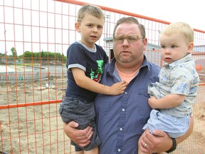 James Higham and his sons Easton (left) and Foster stand outside the unfinished Transcona Aquatics Park in Winnipeg, Man. Tuesday June 14, 2016. Higham is upset about the delays in getting the project completed.
