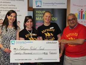 Tina Bailey (left), executive director of the Community Foundation for Kingston & Area, announces a donation of $20,000 to the Community Refugee Relief Fund, represented by members of KEYS (from left) Madeleine Nerenberg, Bridget Glassco and Amr Elsharkawy. (Jane Willsie/For The Whig-Standard)